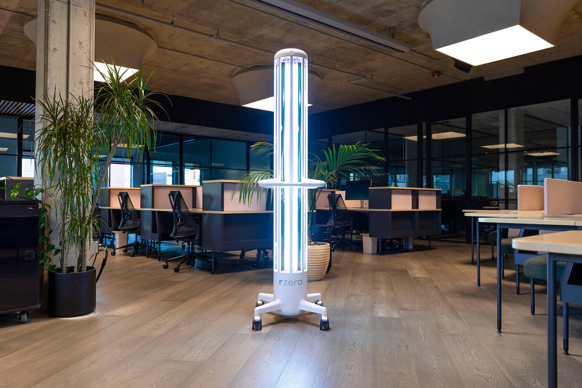 An ARC UV-C disinfection system standing in the middle of an empty office and professional workplace.