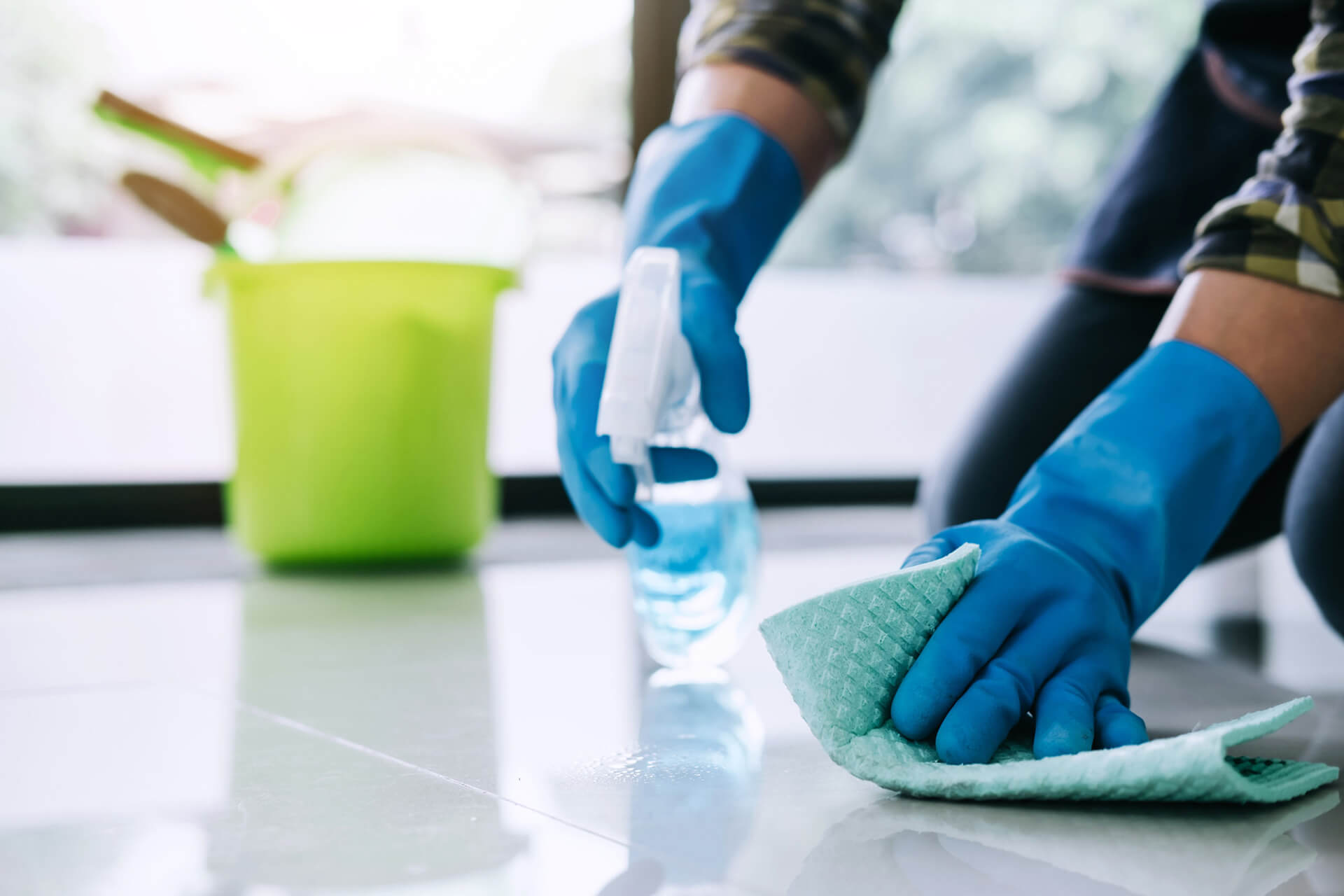 Man in blue gloves cleaning and disinfecting with chemicals